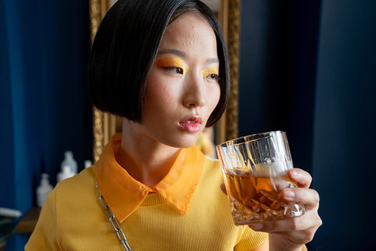 A woman in yellow drinking alcohol